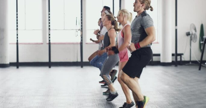 Youve got to challenge yourself to change yourself. Fitness group of active young people doing a workout together at a gym. People jogging or running during exercise. Health, wellness and sport