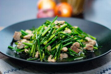 Stir-fried morning glory in a black dish 