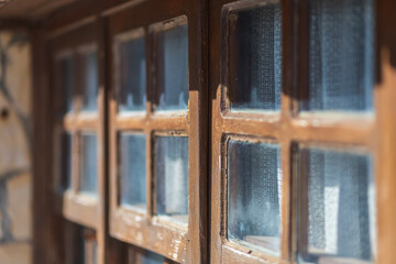 Close-up brown wooden vintage window in an old stone house