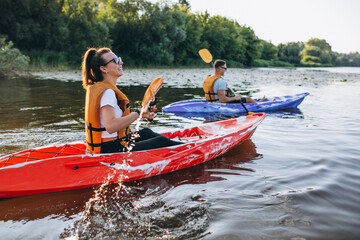 Couple together kayaking on the river - obrazy, fototapety, plakaty