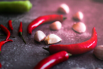 Red chilli and green chilli, garlic spread on the gray table ready to cook in the kitchen.