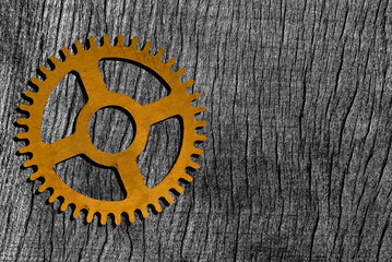 Old clock gear on a wooden background.