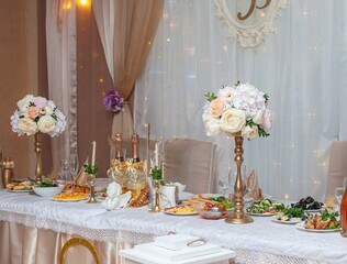 decoration of the wedding table. wine glasses on the table. Bouquets of flowers, snacks.