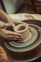 Fototapeta na wymiar A man working on a potter's wheel. Creative work with clay.