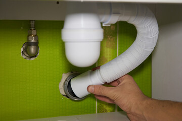 installs a siphon pipe,men's hands install a washbasin siphon