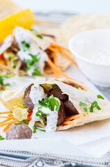 Homemade lamb meatballs in pita flatbread with spicy yoghurt sauce. Close up.