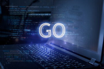 GO inscription against laptop and code background. Technology concept.