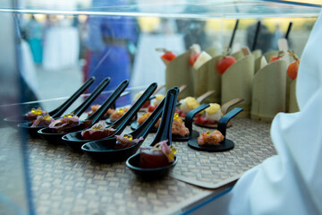 Entrantes y pinchos variados. Atún rojo y salmón. Protegidos con una caja de metacrilato transparente que porta el camarero.