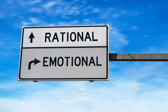 Road sign with words rational and emotional. White two street signs with arrow on metal pole on blue sky background.