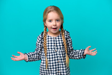 Little caucasian girl isolated on blue background with shocked facial expression