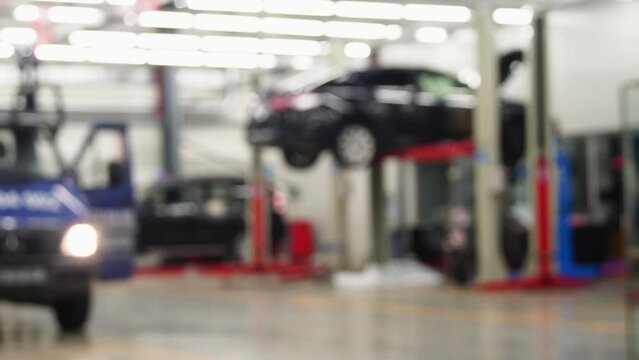 Raised car in professional service repair process, unfocused background. Car service at the dealer . The concept of car repair. The background is out of focus.