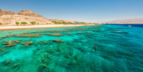 Beautiful coral reefs of the Red Sea, sandy beaches, small tourist hotels and Sinai mountains near Eilat – famous tourist resort and recreational city in Israel.