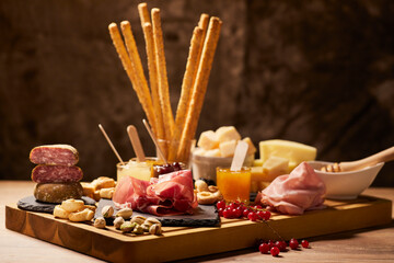 Wooden cutting board with cold cuts and cheeses