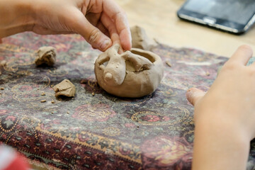 A child molds a product from clay in a modeling lesson.
