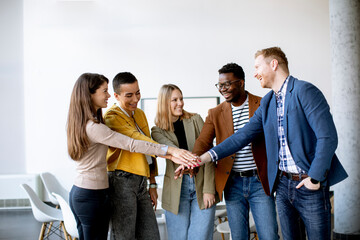 Group of positive businesspeople standing together in the office