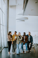 Group of positive businesspeople standing together in the office