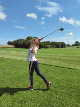 Cute teen girl playing golf on grass at golf club in summer