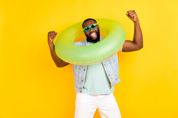 Portrait of attractive trendy cheerful guy wearing life buoy having fun rejoicing isolated over...