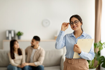 Successful family psychotherapy. Portrait of arab female marital counselor after effective session with married couple
