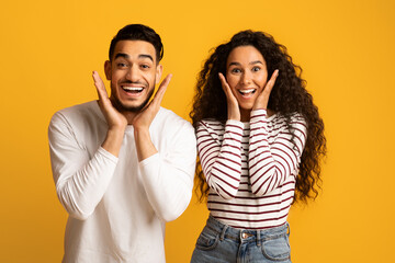 Amazing Offer. Surprised Arab Couple Looking At Camera, Touching Face With Excitement