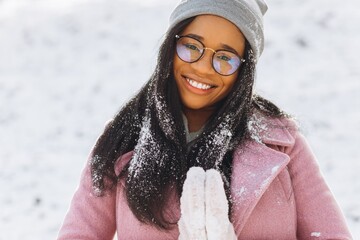 Portrait of happy positive girl, African ethnic Afro American young woman with snow on her hair and...