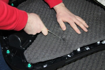 The master installs sound insulation material on the inside of the car door card. The process of installing sound insulation for cars. Sound insulation of the car.Tuning and repair.