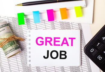 On a light background, a pen, dollars, a notebook with the text GREAT JOB and bright stickers. Business concept