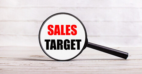 The magnifying glass stands vertically on a light background with the text SALES TARGET