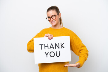 Young caucasian woman isolated on white background holding a placard with text THANK YOU and  pointing it