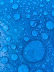 rain water drops on blue cyan turquoise plastic background with copy space 