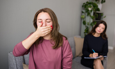 the frustrated female patient covered her mouth with her hand. Depression. An appointment with a...