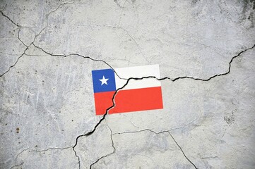An old image of the flag of Chile on a wall with a crack.