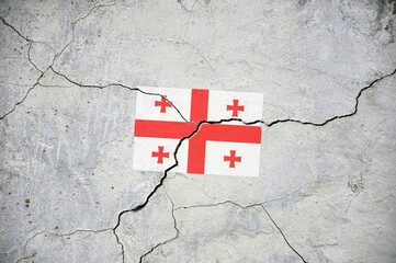 An old image of the flag of Georgia on a wall with a crack.