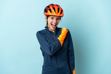 Young cyclist woman isolated on blue background celebrating a victory - obrazy, fototapety, plakaty