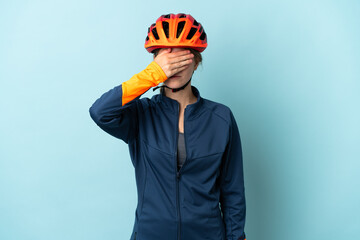 Young cyclist woman isolated on blue background covering eyes by hands. Do not want to see something