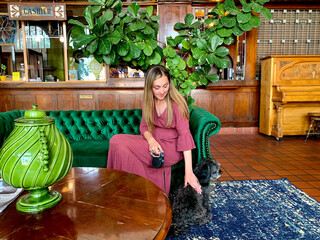 Woman and dog waiting in hotel lobby