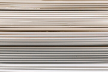 Obraz premium Old PVC plastic panels in a pile of building used recycling construction material. Texture background with lines and stripes pattern