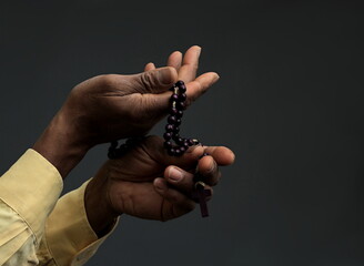 man praying to god with hands together on dark background stock photo