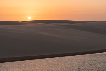 Beautiful sunset view to rainwater lagoon on sand dunes