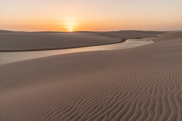 Fototapeta na wymiar Beautiful sunset view to rainwater lagoon and sand texture on dunes