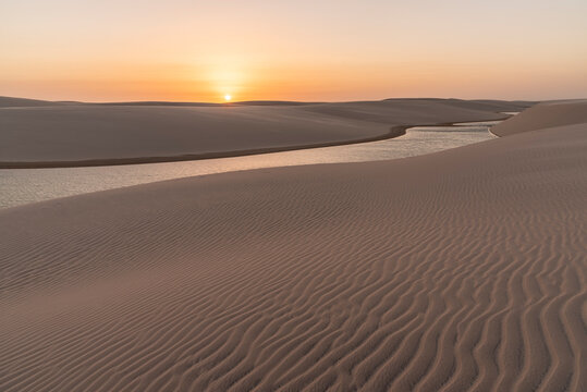 Beautiful sunset view to rainwater lagoon and sand texture on dunes