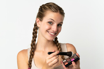 Obraz premium Young caucasian woman isolated on white background with makeup palette and happy