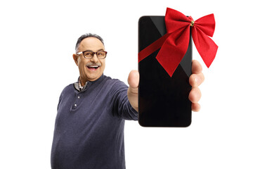 Smiling mature casual man holding a mobile phone with a red ribbon in front of camera