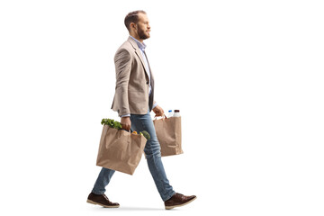 Man walking and carrying two grocery bags