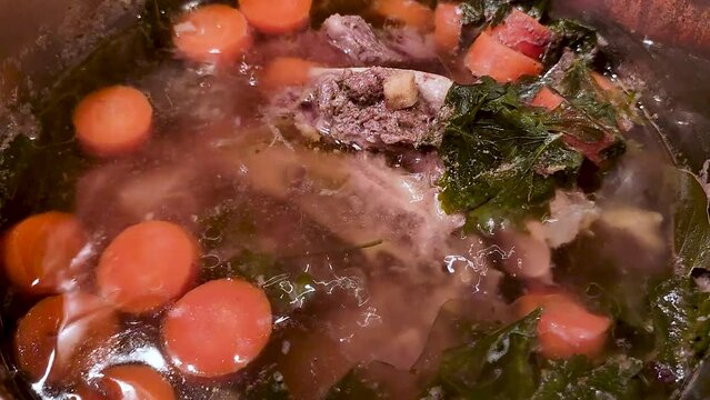 Cooking beef broth soup with carrots. Beef broth knows in Poland as rosol wolowy.