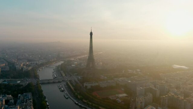 Establishing Aerial Panorama of Paris Skyline with Eiffel Tower as main Landmark Monument at sunrise with beautiful sky. Urban Cityscape of Capital of France as Travel Destination. 4K drone wide shot