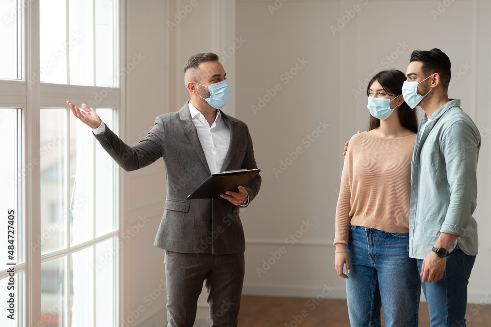 Poster Real Estate Agent In Facemask Showing Young Buyers New Property