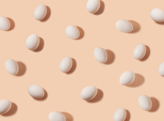 Flat lay pattern of white eggs on a pastel peach color background. Happy Easter day concept