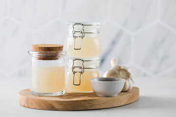 Fototapeta na wymiar Bone broth soup in glass jars for storage on a wooden board. The concept of healthy eating.