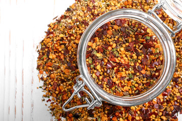 Mix of various spices close-up in a jar on a white wooden background. Textures of colorful spices and seasonings.